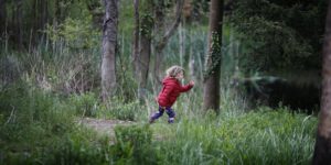 Little girl running through woodland