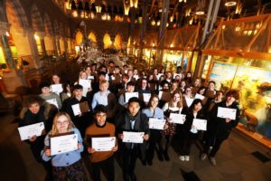 Group of pupils with certificates for Young Scientists of the Year against background of exhibits at Oxford University Museum of Natural History
