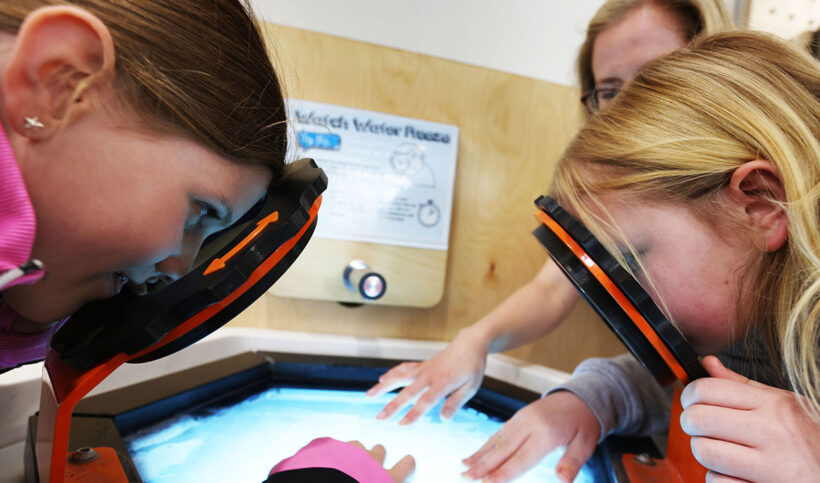 Watch Water Freeze feature image with two children looking through the magnifying viewers at the ice