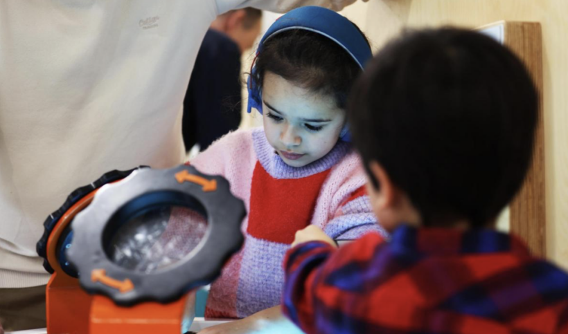 child at Watch Water Freeze exhibit with headphones