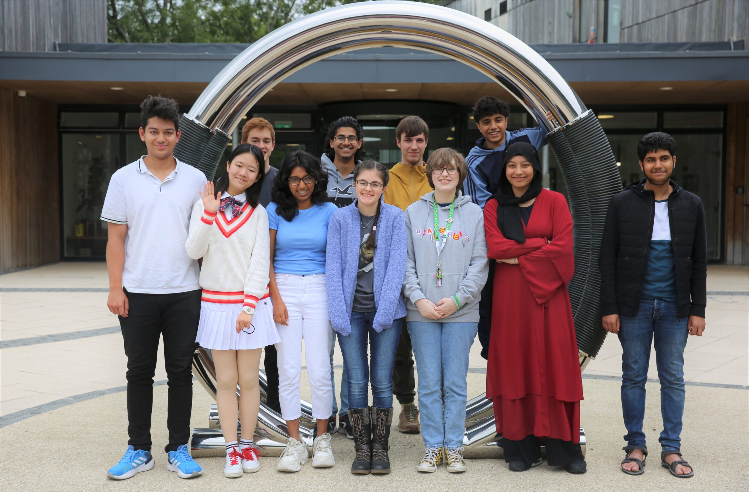 Group of students standing in front of ohm statue at Wood Centre for Innovation