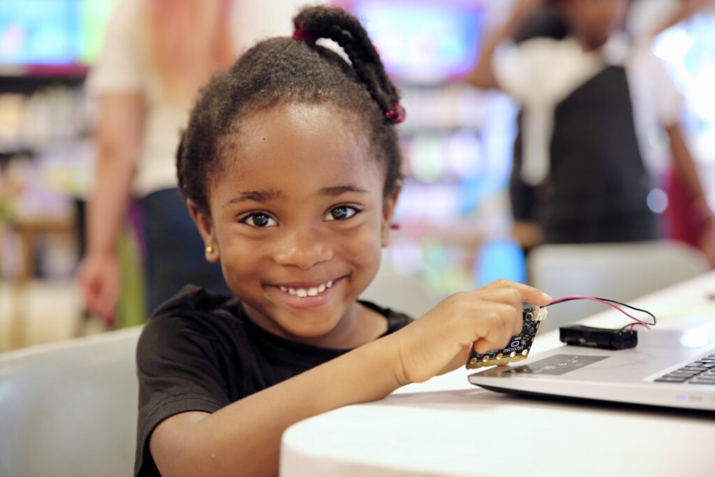 child smiles with laptop