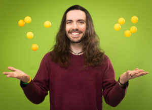 Daniel juggles ping pong balls in the air