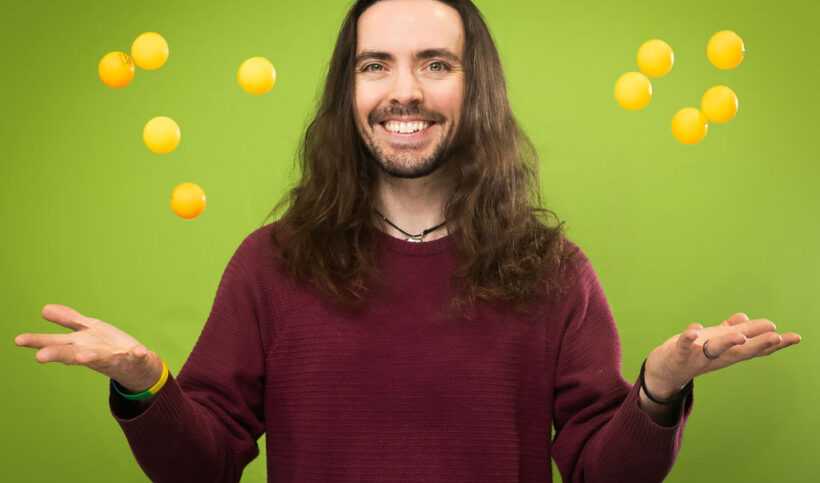Daniel juggles ping pong balls in the air